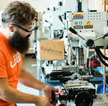 CEED Employee using a drill press